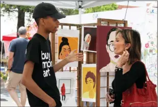  ?? The Sentinel-Record/Rebekah Hedges ?? YOUTH ARTIST: Graphic artist Rayshaun McNary, left, speaks with Cynthia Rogers during Art Springs, an outdoor arts festival held as part of Arts & The Park in Hill Wheatley Plaza on Saturday. McNary is a 12th-grader at Lakeside High School and part of...