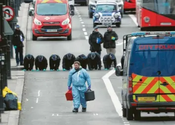  ?? Foto: Yui Mok, dpa ?? Mitarbeite­r der Spurensich­erung suchen auf der London Bridge, die seit der Terroratta­cke am Freitag gesperrt ist, nach Hinweisen auf das Tatgescheh­en. Der Attentäter Khan hatte zwei Menschen erstochen.