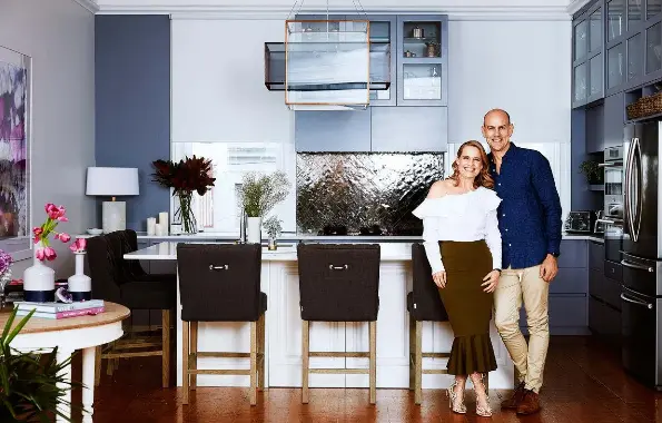  ??  ?? ABOVE: Shaynna with her husband Steve Vaughan, photograph­ed in the kitchen of their home. BELOW: The Block judges (from left) Neale Whitaker, Darren Palmer and Shaynna.