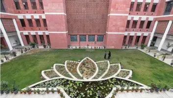  ??  ?? India’s Congress party supporters celebrate outside the party headquarte­rs in New Delhi on Tuesday, whereas Bharatiya Janata Party’s headquarte­rs (Right) looks deserted. — AFP