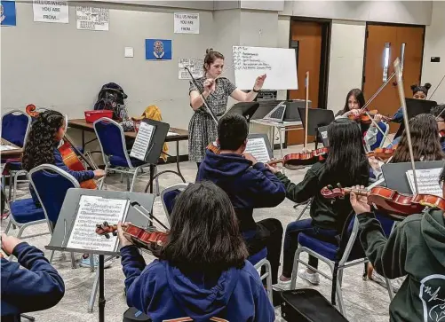  ?? Gulfton Community Youth Orchestra ?? Theodora Prunoske works with members of the Gulfton Community Youth Orchestra in the fall of 2019.