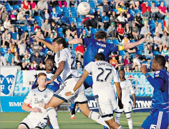  ?? — CP ?? Ethen Sampson of the Whitecaps and FC Edmonton’s Albert Watson battle for the ball during first-half action in the Amway Canadian Championsh­ip semifinal in Edmonton on Wednesday. The Whitecaps move on to the two-leg final against Montreal in August.