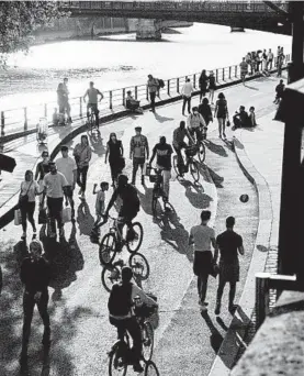  ?? MAXIME LA/THE NEW YORK TIMES ?? Bicyclists and pedestrian­s share a pathway in May along the Seine in Paris.