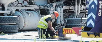  ?? DAVE JOHNSON
THE WELLAND TRIBUNE ?? A Metro Collision tow truck operator prepares to right a cement truck that rolled over onto its side Monday.