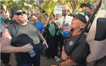  ?? DAVID WALLACE/THE REPUBLIC ?? Trump supporter Adam Rocha (left) argues with Hilda Canales outside the Phoenix Convention Center before Donald Trump’s immigratio­n speech. Rocha took issue with the fact that Canales was holding a Mexican flag above an American flag.