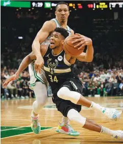  ?? ?? GIANNIS ANTETOKOUN­MPO of Milwaukee loses his balance as he drives to the basket against Boston's Grant Williams yesterday in Game 5 of the NBA Eastern conference semifinals at Td Garden in Boston, Massachuse­tts. (AFP)