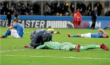  ?? PHOTOS: GETTY IMAGES ?? As the Swedish team celebrates, left, Italy players slump to the ground in despair after a 0-0 stalemate in Milan meant the Azzurri failed to qualify for the World Cup for the first time in 59 years.