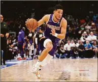  ?? Tony Gutierrez / Associated Press ?? Phoenix Suns guard Devin Booker drives to the basket during Game 3 of a second-round playoff series against the Dallas Mavericks on Friday.