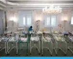  ?? —AFP ?? KIEV: A nurse cares for newborn babies at Venice Hotel on Friday.