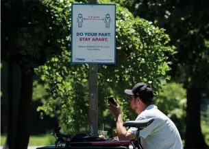  ?? NATHAN DENETTE THE CANADIAN PRESS ?? A man uses his smartphone in Toronto on Thursday. While Ontario continues to log more than 170 new cases a day, B.C. declared the regional curve was flattening on April 17.