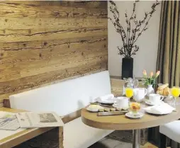  ?? DEBBIETRAV­IS.COM ?? Recycled barn board warms up this breakfast nook at the Hotel les Armures in Geneva, Switzerlan­d.