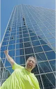  ??  ?? Wes Attwood stands on a public bench at the Easter Seals Drop Zone in Regina on Saturday. The self-described adrenalin junkie from Rouleau rappelled down the building behind him earlier in the day.