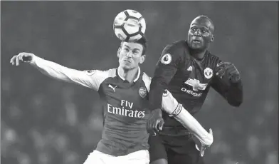  ?? ANDREW COULDRIDGE / ACTION IMAGES VIA REUTERS ?? Arsenal’s Laurent Koscielny beats Manchester United’s Romelu Lukaku to a header during Saturday’s English Premier League match at Emirates Stadium in London on Saturday. United won 3-1.