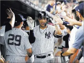  ?? Frank Franklin II ?? The Associated Press New York Yankees slugger Giancarlo Stanton celebrates with teammates after hitting a two-run home run against the Atlanta Braves on Tuesday in New York.