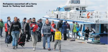  ??  ?? Refugees escorted off a ferry back to Turkey last month