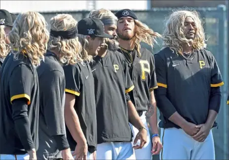  ?? Matt Freed/Post-Gazette ?? A BLOND SPRING Pirates pitchers pay a fun homage to the flowing locks of teammate Blake Cederlind, third from left, during pregame wearmups Saturday at Pirate City in Bradenton, Fla.