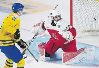  ?? HUGHES/THE CANADIAN PRESS GRAHAM ?? Sweden’s Carl Grundstrom scores on Denmark goaltender Lasse Petersen in the world juniors Monday.