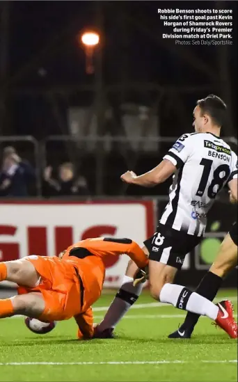  ?? Photos: Seb Daly/Sportsfile ?? Robbie Benson shoots to score his side’s first goal past Kevin Horgan of Shamrock Rovers during Friday’s Premier Division match at Oriel Park.