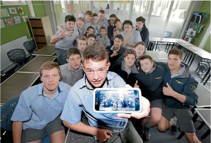  ?? ROBYN EDIE/STUFF 634715905 ?? Gore High School under-15 rugby team captain Hayden Michaels with the message of support All Blacks Damian McKenzie and Liam Squire sent the team.