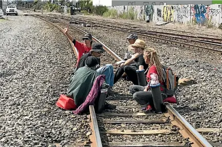  ?? PHOTO: IAIN MCGREGOR/STUFF ?? Six people locked themselves to a train track in Christchur­ch in protest against the re-branded TPPA.