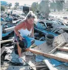  ?? RUSS BYNUM THE ASSOCIATED PRESS ?? Dena Frost salvages an unbroken clay pot from the wreckage of her pottery business in Mexico Beach, Fla.