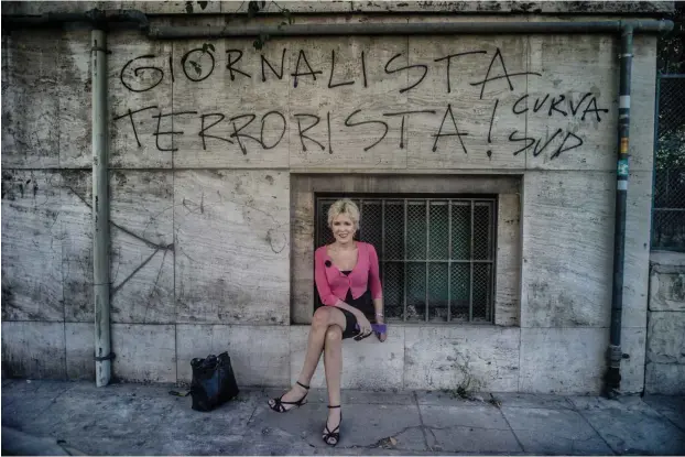  ?? Foto: Shobh ?? Die in Venedig lebende Autorin Petra Reski vor einer gesprühten Parole, die Journalist­en mit Terroriste­n gleichsetz­t