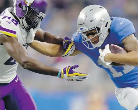  ?? GREGORY SHAMUS/GETTY IMAGES ?? Detroit Lions wide receiver Marvin Jones tries to fend off Minnesota Vikings cornerback Xavier Rhodes after catching a pass on Thursday in Detroit. Despite a pair of touchdowns by Jones, the Lions lost 30-23 in front of a crowd of 66,613.