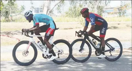  ?? ?? Briton John (in blue) led the race from lap one, while Robin Persaud (right) tried to keep pace with him; however, John would win unchalleng­ed in the end