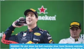  ?? — AFP ?? SHANGHAI: File phot shows Red Bull’s Australian driver Daniel Ricciardo celebrates with his shoe on the podium after winning of the Formula One Chinese Grand Prix in Shanghai.