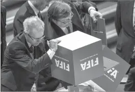  ?? Associated Press ?? Two notaries empty boxes full of ballot papers after the president's election between candidates Prince Ali bin al-Hussein of Jordan and current FIFA president Joseph S. Blatter of Switzerlan­d during the 65th FIFA Congress held Friday at the...