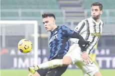  ?? - AFP photo ?? Inter Milan’s Argentine forward Lautaro Martinez (left) and Juventus’ Uruguayan midfielder Rodrigo Bentancur go for the ball during the Italian Serie A football match Inter vs Juventus on January 17, 2021 at the San Siro stadium in Milan.