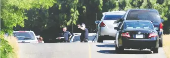  ?? NICK PROCAYLO/FILES ?? Const. Rob Vroom, with his arm raised and wearing a baseball cap, works on the scene of an early morning homicide at Polar Ava and Townline Road in Abbotsford in 2010.