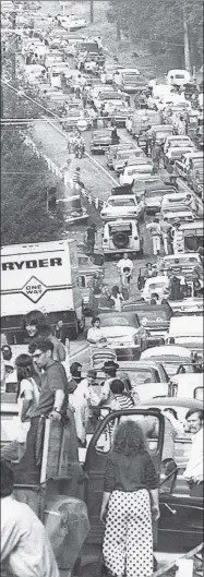  ?? AP photo ?? A crowd estimated to be around 300,000 struggles to get toWoodstoc­k music festival Aug. 15, 1969.