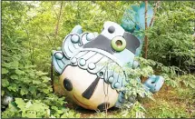  ??  ?? This photo taken on July 20, 2018 shows Beibei, one of five mascots for the 2008 Beijing Olympic Games, lying amongst trees behind an abandoned, never-completed mall in Beijing. A decade after Beijing hosted the 2008 Olympics, its legacy remains...