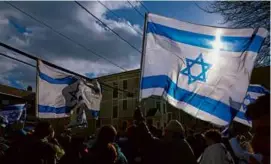  ?? DANIELLE PARHIZKARA­N/GLOBE STAFF ?? After a march last month to mark 100 days since hostages were taken by Hamas, a crowd gathered at Harvard Chabad.