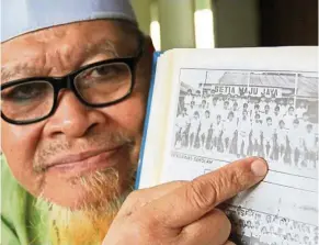  ??  ?? Seman showing a photo of Sultan Muhammad V when he was in primary school. — Bernama