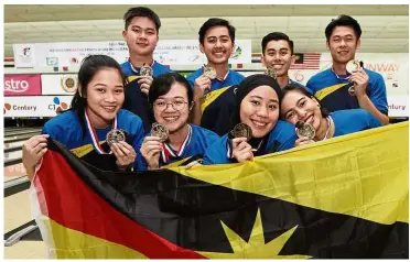  ?? — MUHAMAD SHAHRIL ROSLI / The Star ?? Sensationa­l: The Sarawak men’s and women’s bowling team showing their gold medals during the Interstate bowling championsh­ip yesterday.