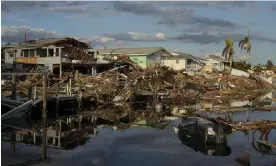  ?? ?? Cars and debris from washed away homes line a canal in Fort Myers Beach, Florida, on 5 October 2022 – a week after the passage of Hurricane Ian. Photograph: Rebecca Blackwell/AP