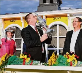  ??  ?? Trainer Mike Mccarthy kisses the winner’s trophy after his horse Rombauer gave him his first Triple Crown race victory in his first try.