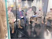  ?? SARAHBLAKE­MORGAN/AP ?? Paratroope­rs from the 82nd Airborne Division and historian John Aarsen, second from left, read postcards sent from the town of SainteMere-Eglise, France. The soldiers’annual trip commemorat­ing D-Day was canceled because of the pandemic.