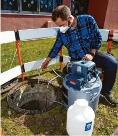  ?? Foto: Marcus Merk ?? Abwasserme­ister Norbert Uhl zieht eine Probe, die dann auf Coronavire­n untersucht wird.