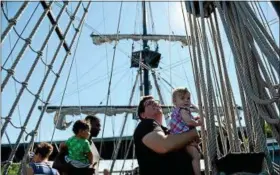  ?? PHOTOS BY TANIA BARRICKLO — DAILY FREEMAN ?? Mark Alizah of Troy, N.Y., holds his 11-month-old daughter Sestina DeVit up to look at the ropes on El Galeón Andalucía, a replica of a Spanish galleon used during the 16-18th centuries docked at the Hudson River Maritime Museum in Kingston, N.Y.,...
