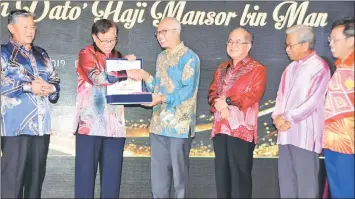  ??  ?? Abang Johari hands over a memento to Mansor (third left) as (from right) Minister of Local Government and Housing Datuk Dr Sim Kui Hian, Masing, Uggah and Morshidi look on.