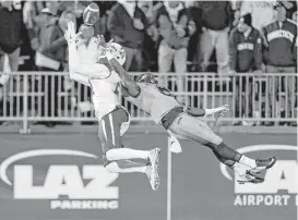  ?? Rich Schultz / Getty Images ?? Chance Allen, left, hauls in a pass from Kyle Postma for UH’s first touchdown despite close coverage by Connecticu­t’s Jhavon Williams.