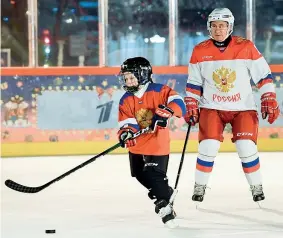  ??  ?? Sul ghiaccio
Il presidente russo Vladimir Putin, 67 anni, gioca a hockey con il piccolo Dmitry, 9, su una pista realizzata sulla Piazza Rossa