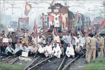  ??  ?? Demonstrat­ors from the Samajwadi Party, a regional political party, shout slogans after stopping a passenger train during a protest against price hikes in fuel and foreign direct investment in retail, near Allahabad yesterday. Government reforms seek...
