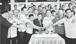  ??  ?? ULANG TAHUN: Dr Sim (depan, empat kanan) bersama Lo (depan, tiga kanan), Ahmad (depan, dua kanan) serta tetamu kehormat lain memotong kek bagi menyambut Ulang Tahun Majlis MPP di Ibu Pejabat MPP, Kota Padawan dekat Kuching, semalam.