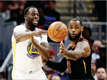  ?? AP PHOTO BY TONY DEJAK ?? Golden State Warriors' Draymond Green, left, passes against Cleveland Cavaliers' Lebron James in the first half of an NBA basketball game, Monday in Cleveland.