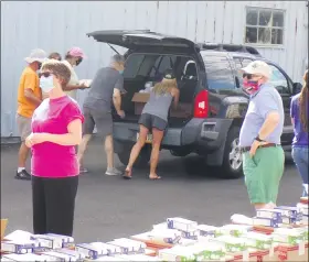  ?? BOB KEELER — MEDIANEWS GROUP ?? Volunteers load food into a vehicle at the Aug. 20 free food distributi­on. Garden of Health has topped 100,000 pounds of food distribute­d this year.