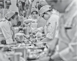  ?? CHERYL EVANS/THE REPUBLIC ?? Hannah Martinez (center) makes salad in an East Valley Institute of Technology class.